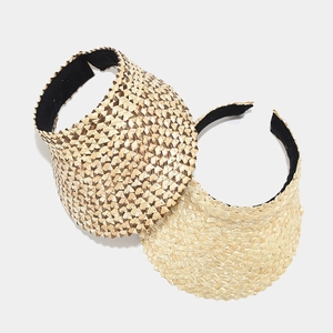 Detail view of woven straw sun visors showing beige and checkered texture with black lining