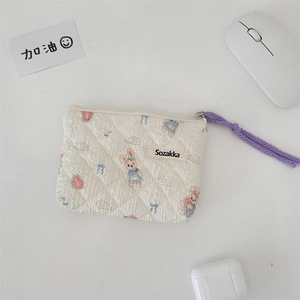 Detailed view of floral quilted cotton pouch with cute rabbit patterns and a purple zipper pull