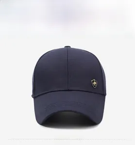 Detail showing deep blue cotton twill baseball cap with golden shield emblem on the side