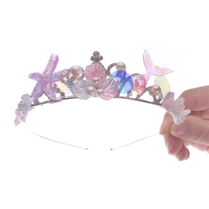 Detail of mermaid crown featuring purple starfish, pink shells, and colorful fish tail