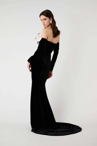 Detail of elegant black velvet off-shoulder gown featuring a white oversized floral chest design