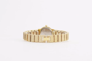 Close-up of gold-tone women's quartz watch back featuring a textured metal link bracelet