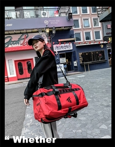Close-up of a red waterproof Oxford fabric travel duffel bag with reinforced black handles