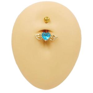 Piercing de nombril cœur doré avec gemme bleue et ailes d'ange sur modèle en peau
