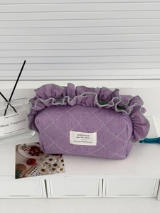 Detail of purple gingham quilted storage bag with ruffle edges and decorative label