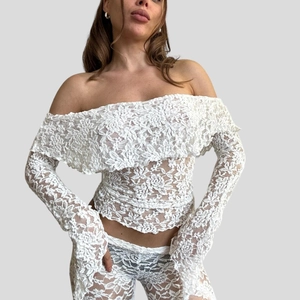 Detailed view of the delicate white lace fabric and textured hollow-out embroidery