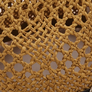 Gros plan détaillé sur la texture en paille tressée main brun-doré et le maillage ajouré