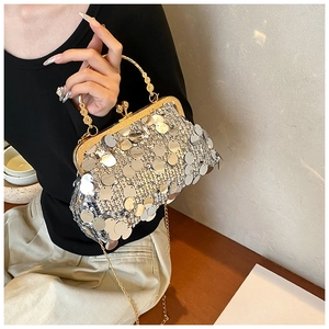 Detail of silver sequin clutch bag featuring a gold frame and spherical clasp with chain