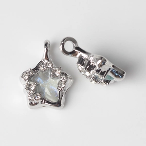 Macro view of star-shaped alloy pendant with iridescent resin and zircon accents