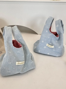Denim mini wrist bag with bow and star patterns featuring red plaid lining and strap