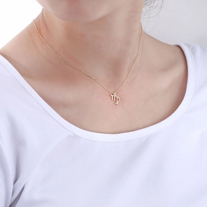 Close-up of golden S925 silver Virgo constellation pendant with sparkling diamonds on neck