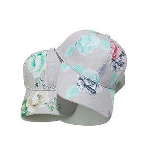 Close-up of floral print baseball caps in grey linen fabric with vibrant flower patterns