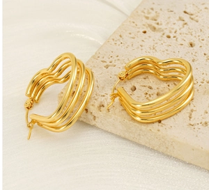 Close-up of golden stainless steel heart-shaped earrings with unique triple-layer wave texture