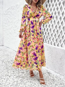 Détail de la robe longue à fleurs jaunes avec manches longues et découpe sur le côté