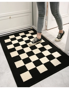 Detail of black and white checkered entryway mat showing plush texture and non-slip use