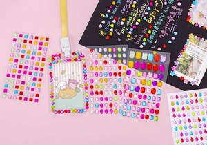 Close-up of colorful self-adhesive acrylic rhinestones and DIY decorated photo card cases
