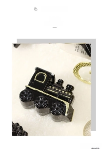 Detail of vintage black train ornament with gold glitter accents for Christmas decor