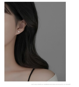 Close-up of elegant 925 sterling silver butterfly stud earrings worn on model's ear