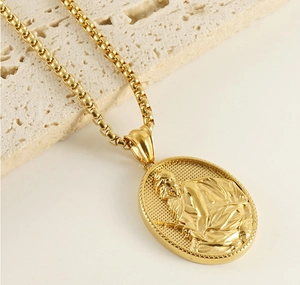 Macro detail of 18K gold-plated priest portrait pendant and textured back on box chain