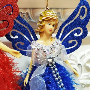 Detailed view of blue sequined Christmas angel ornament with golden hair and lace wings