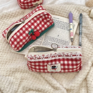 Detail of cherry plaid knit pencil cases with lace trim and soft flannel texture