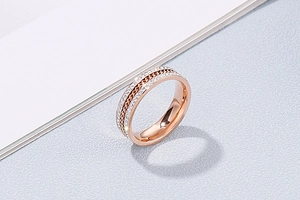 Detail view of rose gold titanium ring with chain texture and sparkling zircon inlay
