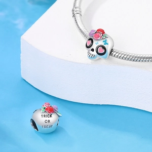 Macro shot of silver Halloween skull charm and Trick or Treat engraved bead
