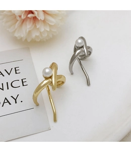 Detailed view of pearl hair clips in gold and silver finish on a clean background
