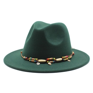 Détail d'un chapeau fedora en laine vert foncé avec bandeau perlé et pendentifs