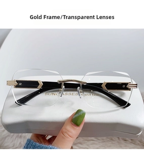 Detail of rimless glasses featuring gold frame and transparent lenses with geometric temples