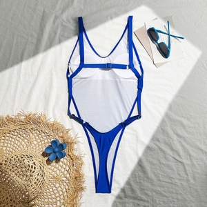 Detailed flat lay of royal blue one-piece swimsuit with V-neck and thin straps on grey fabric
