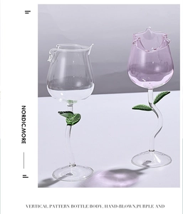 Detail of hand-blown rose-shaped wine glasses with delicate green leaf accents