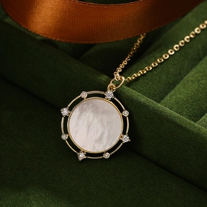Collana dorata con ciondolo a quadrifoglio in madreperla e zirconi su velluto