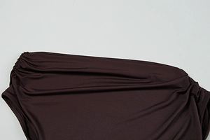 Close-up of ruched dark brown fabric showing the texture of a chic off-shoulder dress