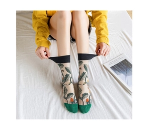 Detail of sheer mesh crew socks with floral embroidery and elastic black cuffs