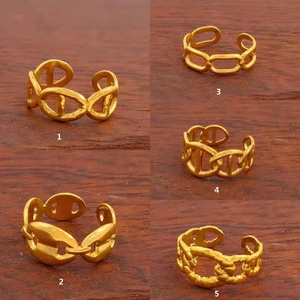 Detail of five adjustable gold-plated rings with classic anchor chain link designs