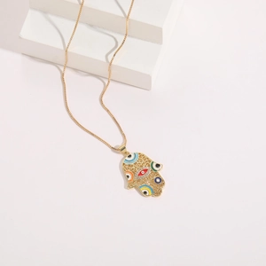 Macro detail of gold plated Hand of Fatima pendant with evil eye and colorful enamel