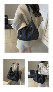 Close-up of black PU leather tote bag with vertical zippers and metal buckle details