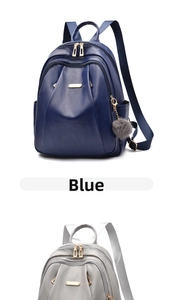 Detail of blue and grey PU leather backpacks with golden zippers and plush charms