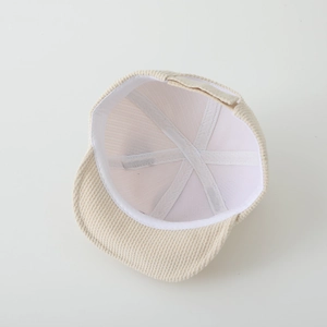 Intérieur détaillé de la casquette en velours côtelé beige montrant la couture à six pans