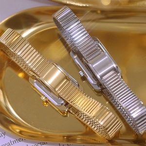 Luxury square women's watches in gold and silver steel on a gold display tray