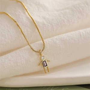Macro view of gold box chain necklace with robot pendant and purple cubic zirconia stone