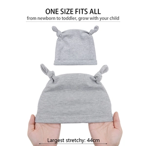 Détail montrant la haute élasticité du bonnet en tricot gris extensible jusqu'à 44cm
