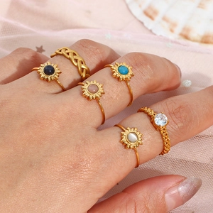 Model wearing gold sunflower ring set featuring colorful cat eye stones and braided bands