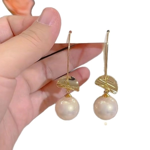 Elegant drop earrings featuring textured gold metal plates and large white pearls