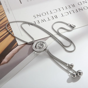 Silver Y-shaped tassel necklace with crystal pavé circle pendant on magazine background