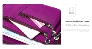 Detailed view of the multi-layer zipper compartments in this purple nylon shoulder bag