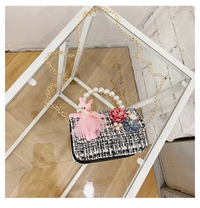 Detail of tweed crossbody bag with pearl handle and pink bunny plush toy for kids
