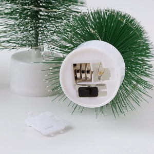 Detail shot of the Christmas tree base showing the battery compartment and LED switch