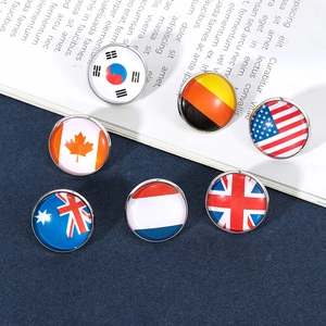 Close-up of 6 national flag badges with glass dome and metal base on an open book